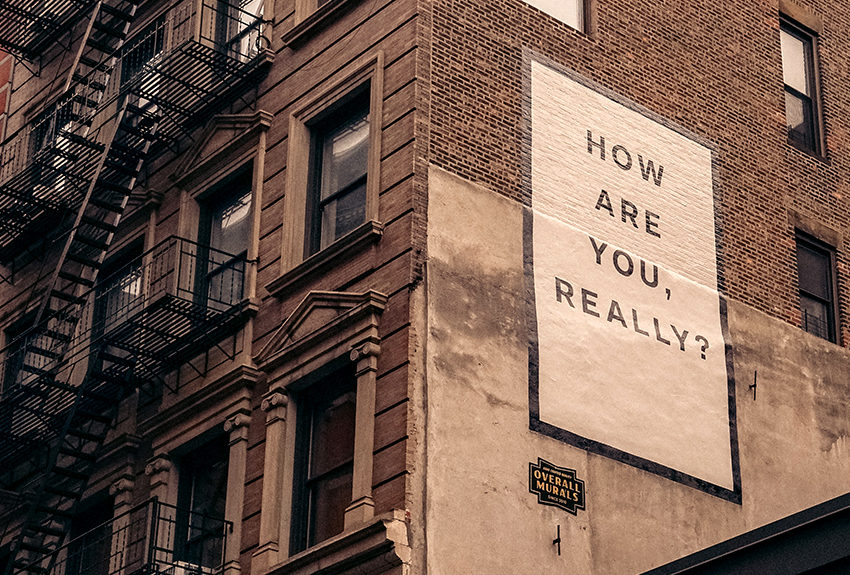 Mural on the side of a brick building that reads "how are you really?"
