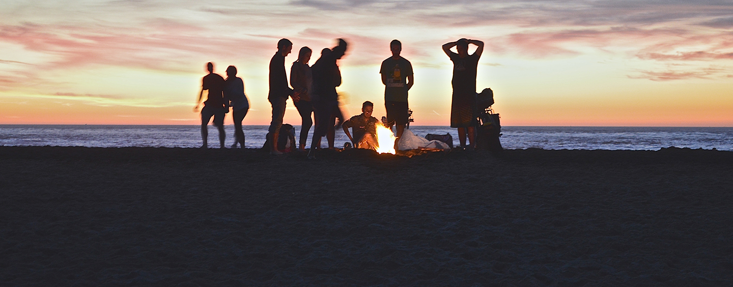 Group of people enjoying a fire on the beach