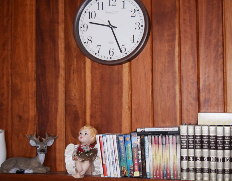 Clock on a wall with books and dvds