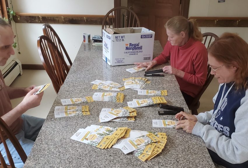 Participants of Citizen Advocates' Enhanced Day Habilitation Program help out by assembling seed and brochure packets for the Adirondack Pollinator Project