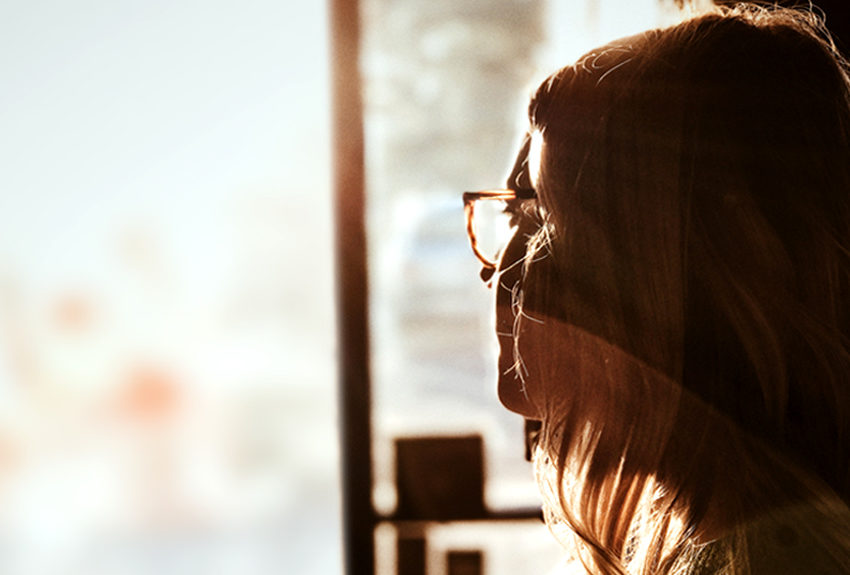 Woman longingly staring out window
