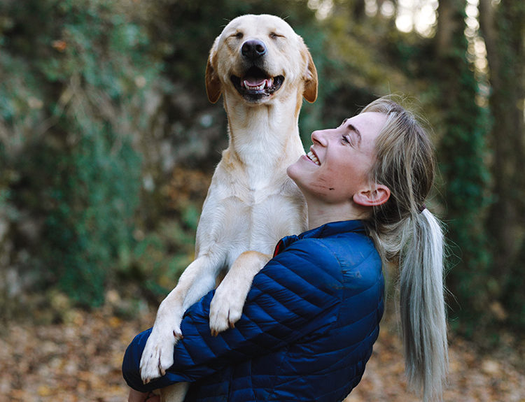 Person happy and healthy, holding dog on walk
