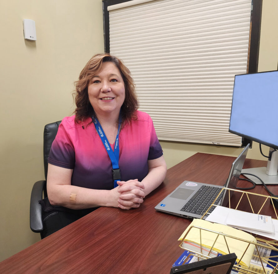 A nurse sits at a computer