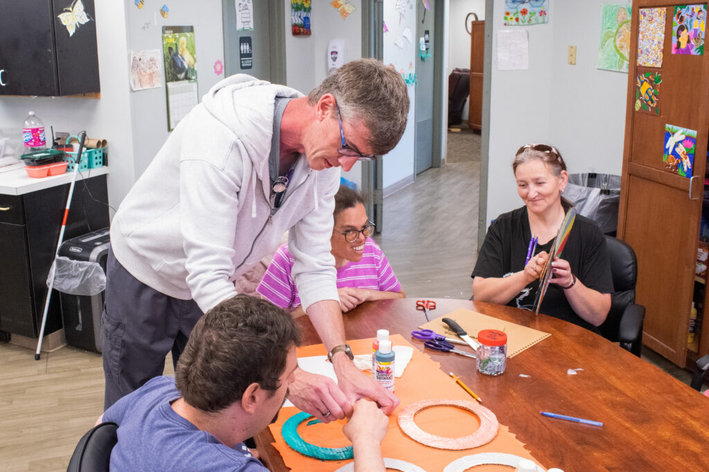 DSP Michael Mersinger works with Lucinda Fish to engage Christopher Riley and Tiffany Maiorana in a craft project.