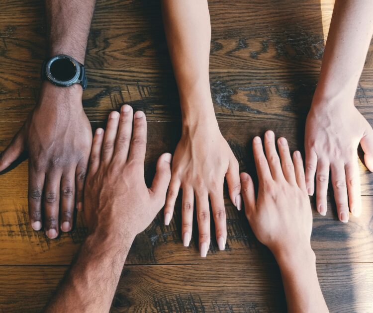 Support group members put their hands together in unity.