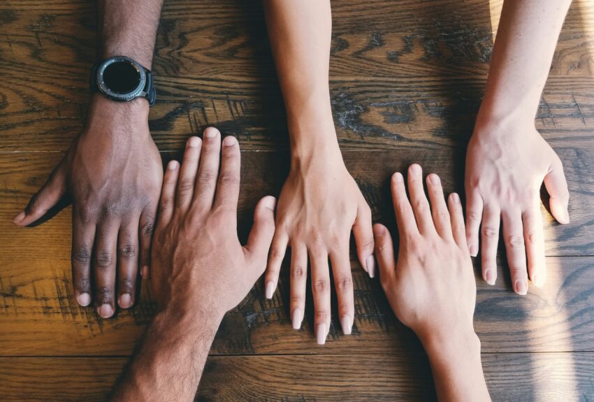 Support group members put their hands together in unity.