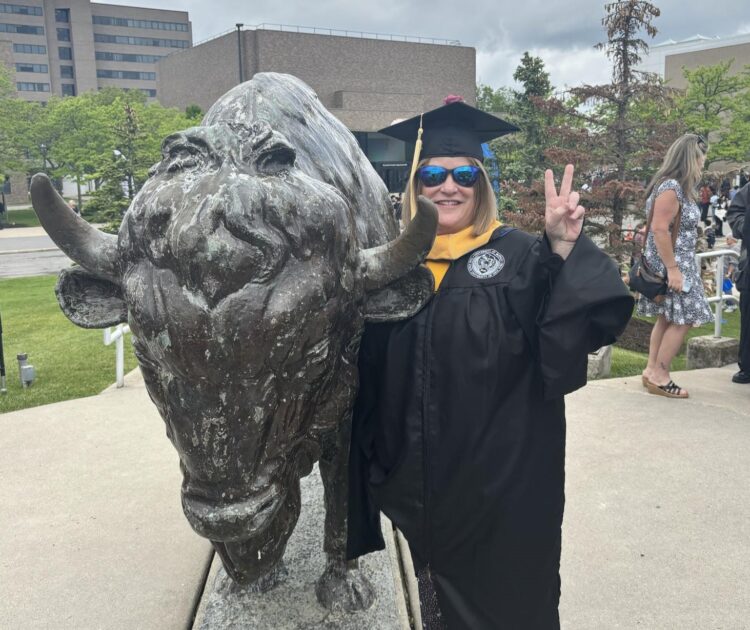 A woman celebrates her graduation her Master of Social Work program after using Citizen Advocates' Tuition Assistance Program.