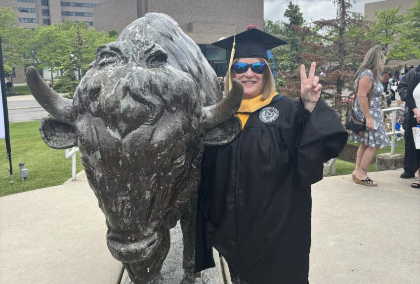 A woman celebrates her graduation her Master of Social Work program after using Citizen Advocates' Tuition Assistance Program.