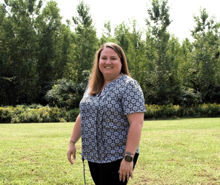 Susan Moore, Customer Support Team Lead at Citizen Advocates' Massena Outpatient Behavioral Health Clinic, stands outside on a sunny day. Her role exemplifies the impact of a Customer Support job in behavioral health.