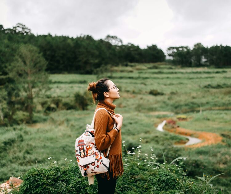 A woman standing in an open field, gazing into the distance, symbolizing reflection and resilience. This image connects to the topic 'how addiction affects mental health,' exploring the emotional and psychological challenges faced by individuals on their recovery journey.