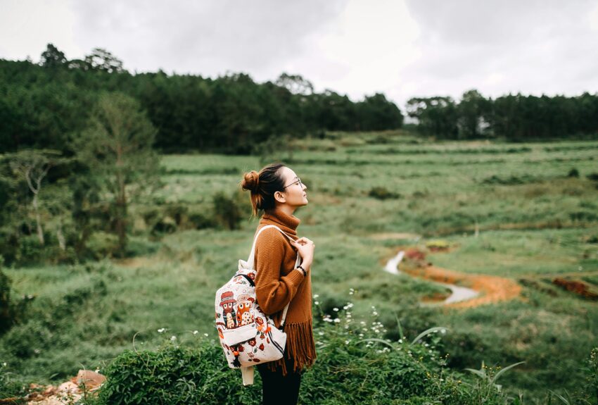 A woman standing in an open field, gazing into the distance, symbolizing reflection and resilience. This image connects to the topic 'how addiction affects mental health,' exploring the emotional and psychological challenges faced by individuals on their recovery journey.