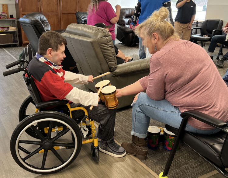 A program participant drums along with a direct support professional at a concert held at Citizen Advocates' Day Habilitation program.