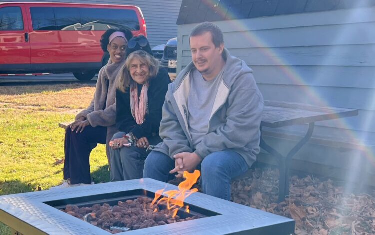 Community club members enjoy a brisk fall day by the outdoor fireplace.