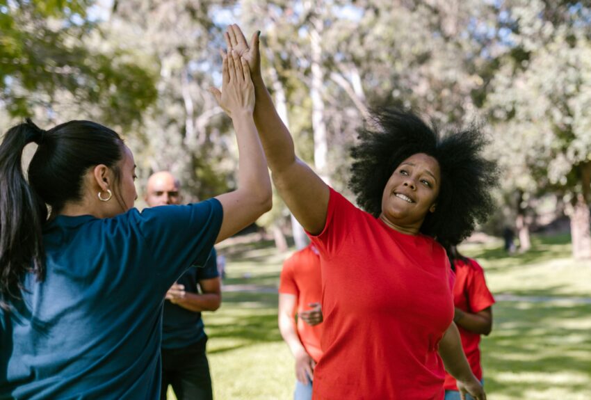 Two women high-five, celebrating the independence possible through self-direction services.