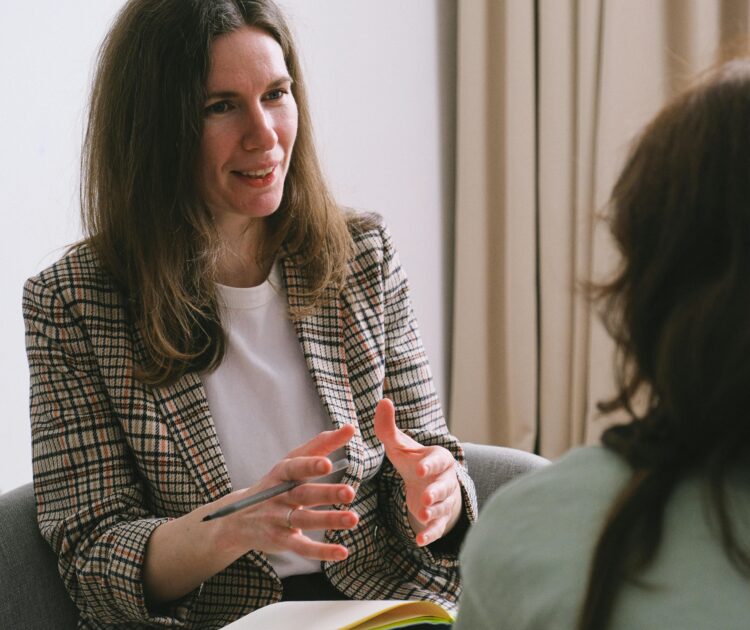 A therapist conducts a talk therapy session with a patient.