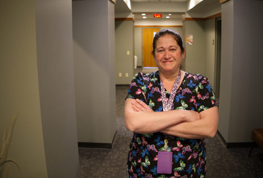 Associate Director Kamie O'Connor stands in the clinic, exemplifying excellence in behavioral health urgent care nursing.