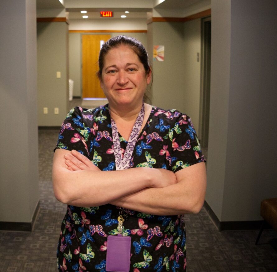 A nurse stands with her arms crossed proud of her career at Citizen Advocates.