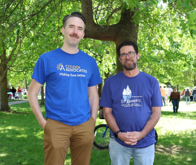 Edward Kirkpatrick and Trevor Buchanan, members of the Citizen Advocates Network Communications & Marketing team, smiling together at a community outreach event.
