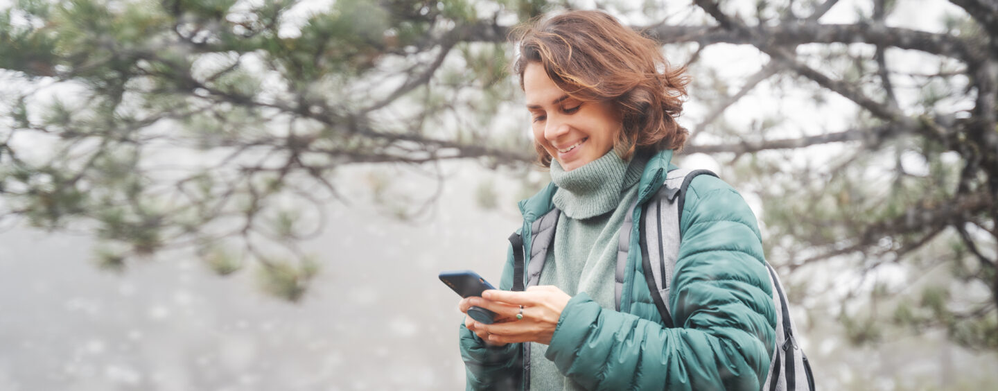 A woman on her cellphone accesses Citizen Advocates patient portal from a hike.