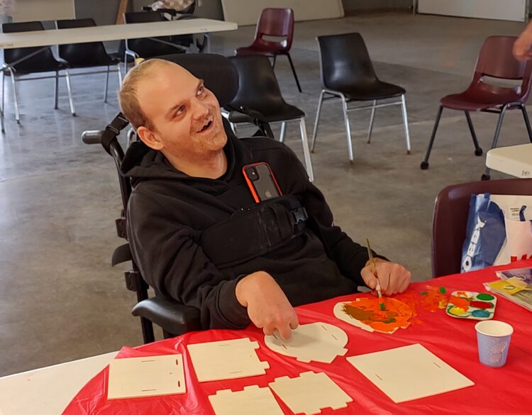 A Day Habilitation participant leads a birdhouse making class for his peers.