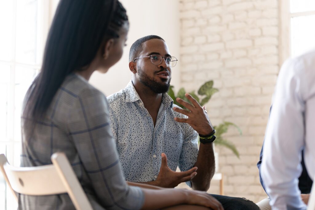 An excited man engages in a group existential therapy session.