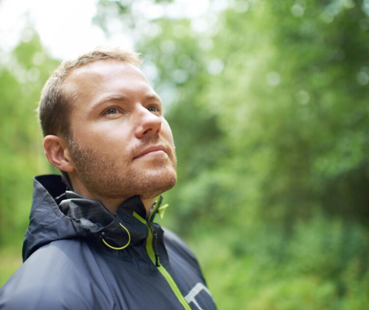 A young man looking at the nature around him and the power of existential therapy.