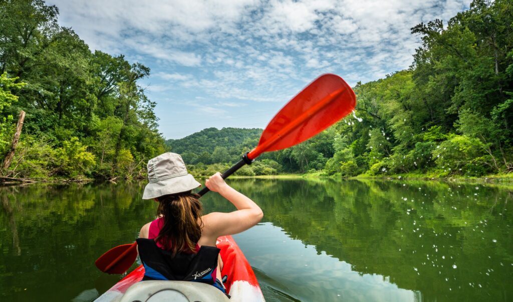 A woman paddles a kayak, having regained her strength and bounced back from relapse.