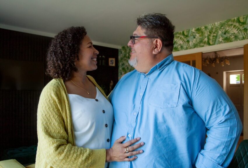A woman and man embrace inside their well-decorated home.