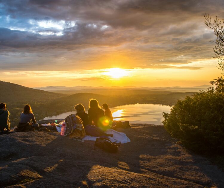 A group of friends enjoys a picnic on a mountain top.