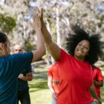 Two women high-five, celebrating the independence possible through self-direction services.